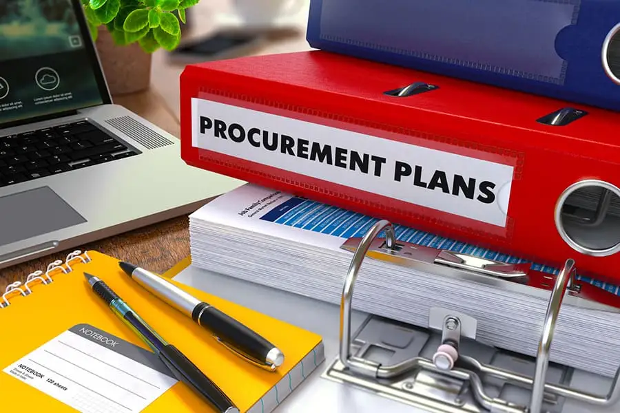 A procurement team reviewing supplier contracts and purchase orders at a desk